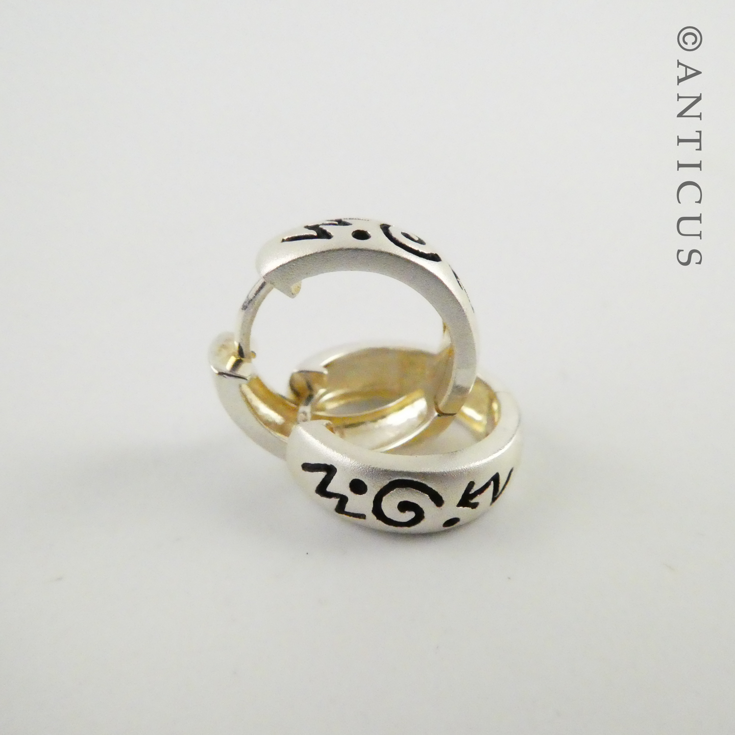 Small Silver Hoop Earrings with Abstract Design.