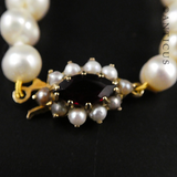 Strand of Pearls with Gold and Garnet Clasp.