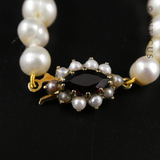 Strand of Pearls with Gold and Garnet Clasp.